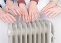 Family warming up hands over electric heater