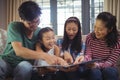 Family watching photo album together in living room