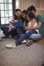 Family watching photo album together in living room Royalty Free Stock Photo