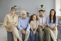 Multi generational family sitting on sofa at home and watching television together Royalty Free Stock Photo