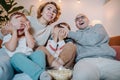 Family watching television together on couch, parents covering children`s faces Royalty Free Stock Photo