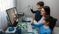 Family waving on video call with grandmother