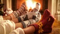 Family wearing knitted woolen socks warming feet at fireplace on Christmas eve Royalty Free Stock Photo