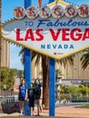 Family wearing mask taking picture under the Welcome to Fabulous Las Vegas Sign