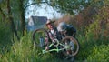 Family weekend, handsome grandfather with beautiful grandson in napper have fun and checks pedals and wheels of bicycle