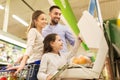 Family weighing oranges on scale at grocery store Royalty Free Stock Photo