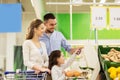 Family weighing oranges on scale at grocery store Royalty Free Stock Photo