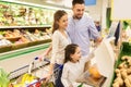 Family weighing oranges on scale at grocery store Royalty Free Stock Photo