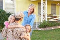 Family Welcoming Husband Home On Army Leave Royalty Free Stock Photo