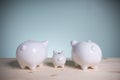 Family white three piggy bank on old wood looking at green background. Father and mother little piggyback training save money for Royalty Free Stock Photo