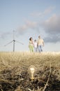 Family and wind turbines, light bulb in the ground Royalty Free Stock Photo