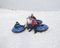 Family winter fun. Sledding and playing in snow Royalty Free Stock Photo