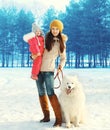 Family in winter, happy mother and child walking with white Samoyed dog Royalty Free Stock Photo