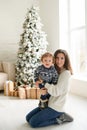 Family, Winter Holidays And People Concept - Happy Mother And Baby Boy Near Christmas Tree At Home