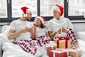 happy family eating coookies in bed on christmas