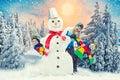 A family in a winter snowy forest mold a big snowman.Family winter fun for Christmas vacation. Royalty Free Stock Photo