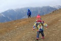 Family winter travel - little girl and boy hiking in mountains