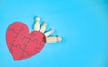 Family wooden dolls, parents and children, happy, on a heart-shaped jigsaw puzzle, red, family unity concept, love, strong bond,