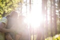 Family in woods embracing with sunlight