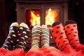 Family in woolen socks warming feet by fire in winter Royalty Free Stock Photo