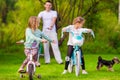 Family of young father and little kids biking at