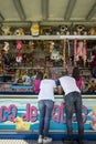 Family with 2 young girls playing at a hook a duck stand