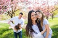 Young parents with small daugthers standing outside in spring nature. Royalty Free Stock Photo