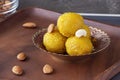 Famous authentic Indian sweets Laddu made from besan or chickpeas flour. Vegetarian and healthy food. Wooden plate background.