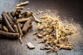 Famous ayurvedic herb Licorice root or Mulethi on wooden surface along with its powder.