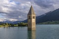 The famous bell tower of old Curon, submerged in Lake Resia, South Tyrol, Italy, with the snow capped Alps in the background Royalty Free Stock Photo