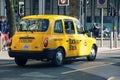 Famous british yellow taxi cab on London street on sunny day