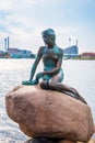 Famous bronze sculpture of a melancholy little mermaid on the waterfront - symbol of Copenhagen, Denmark. Exotic amazing places.