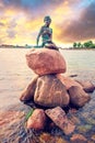 Famous bronze sculpture of a melancholy little mermaid on the waterfront - symbol of Copenhagen, Denmark. Exotic amazing places.