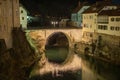Famous Capuchin or kapucinski bridge, a stone bridge in the centre of Skofja Loka, Slovenia on a dark night. Bridge rising aboe Royalty Free Stock Photo