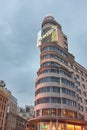 Famous Carrion aka Capitol building located on Gran Via street in Madrid with a cloudy sky as dusk goes on Royalty Free Stock Photo