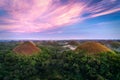 The famous Chocolate Hills of Bohol during sunset with whispy purple clouds and a cloudy fog drenched forest below