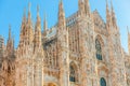 Famous church Milan Cathedral Duomo di Milano with Gothic spires and white marble statues. Top tourist attraction on piazza in Royalty Free Stock Photo