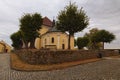 Famous Church of Our Lady of Carmel is surrounded by trees in Kostelni Vydri village in cloudy summer day