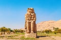 Famous Colossi of Memnon - massive ruined statues of the Pharaoh Amenhotep III. Travel and tourist landmarks. Luxor, Egypt -