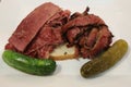 Famous Corned Beef and Pastrami on rye sandwich served with pickles Royalty Free Stock Photo