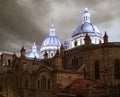 Famous domes of the New Cathedral in Cuenca, Ecuador rise over the city skyline at dusk