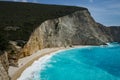 Famous empty hellenic beach on a sunny spring day with a turquoise sparkling sea under the woody cliff