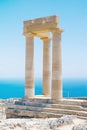 Famous Greek temple pillar against clear blue sky and sea in Greece