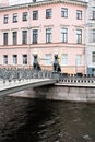 St. Petersburg, Russia, January 2020. Famous griffins of the Bank Bridge on the background of a pink building.