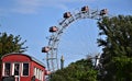 The famous and historic Ferris wheel at the Prater in Vienna, between the green of the leaves and the blue sky. Royalty Free Stock Photo