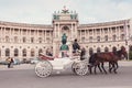 Hofburg Palace and Heldenplatz with a passing carriage with a pair of horses, Vienna, Austria Royalty Free Stock Photo