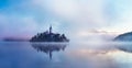 Famous island with old church in the city of Bled. Misty morning