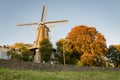 Dutch windmill and trees in autumn colors situated in Gouda, Holland Royalty Free Stock Photo