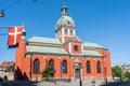 Famous landmark in Stockholm. Church of St. James. In the foreground, the Danish flag hangs on the wall of Danish embassy Royalty Free Stock Photo