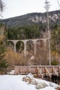 The famous Landwasser Viaduct Bridge in Switzerland with a house and a wooden bridge in the foreground - A cold day in late Royalty Free Stock Photo